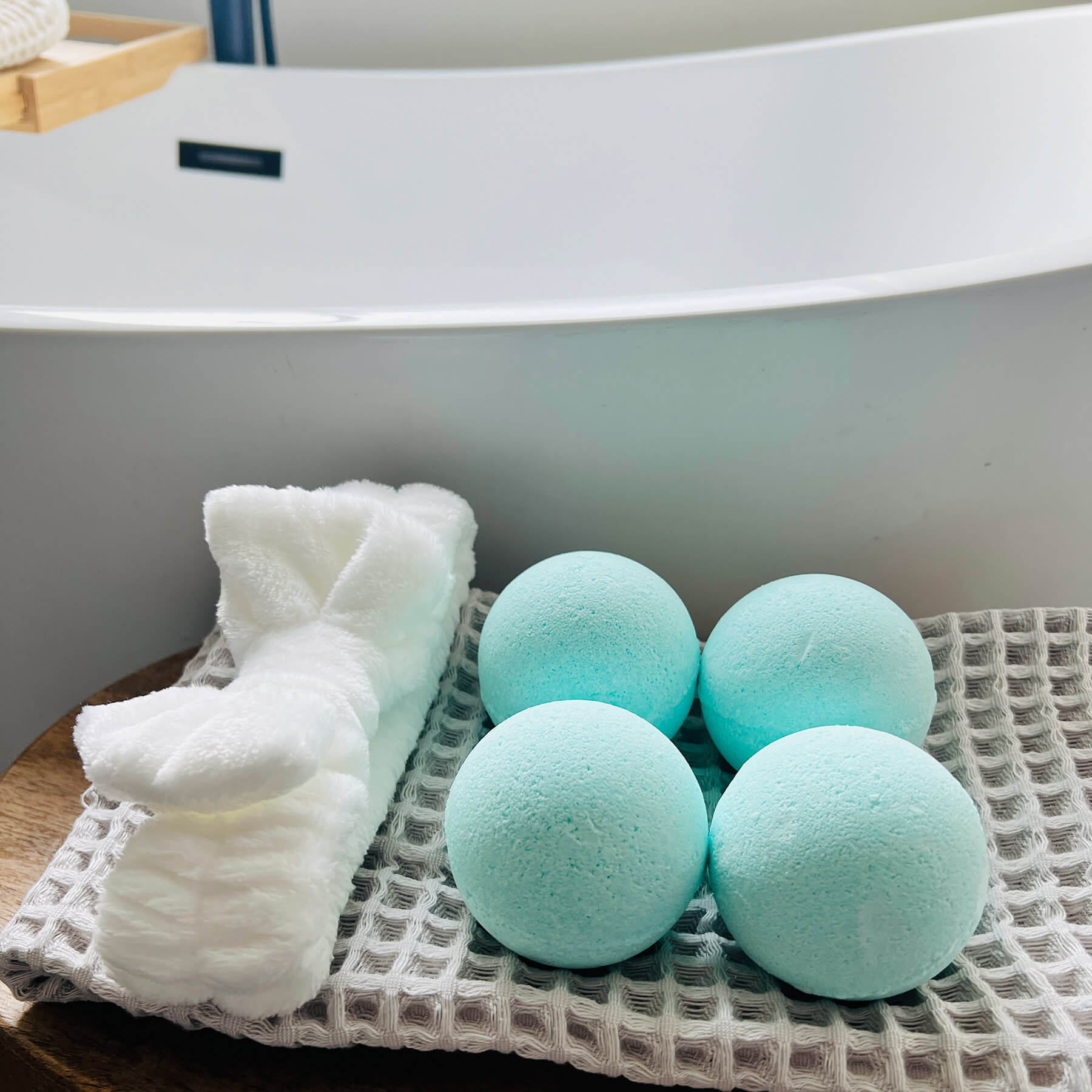 blue bath bombs on a waffle cloth next to a handband on a shelf next to the bath